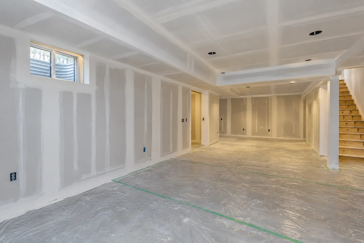 Oakville basement during drywall installation with coordinated ceiling bulkheads.