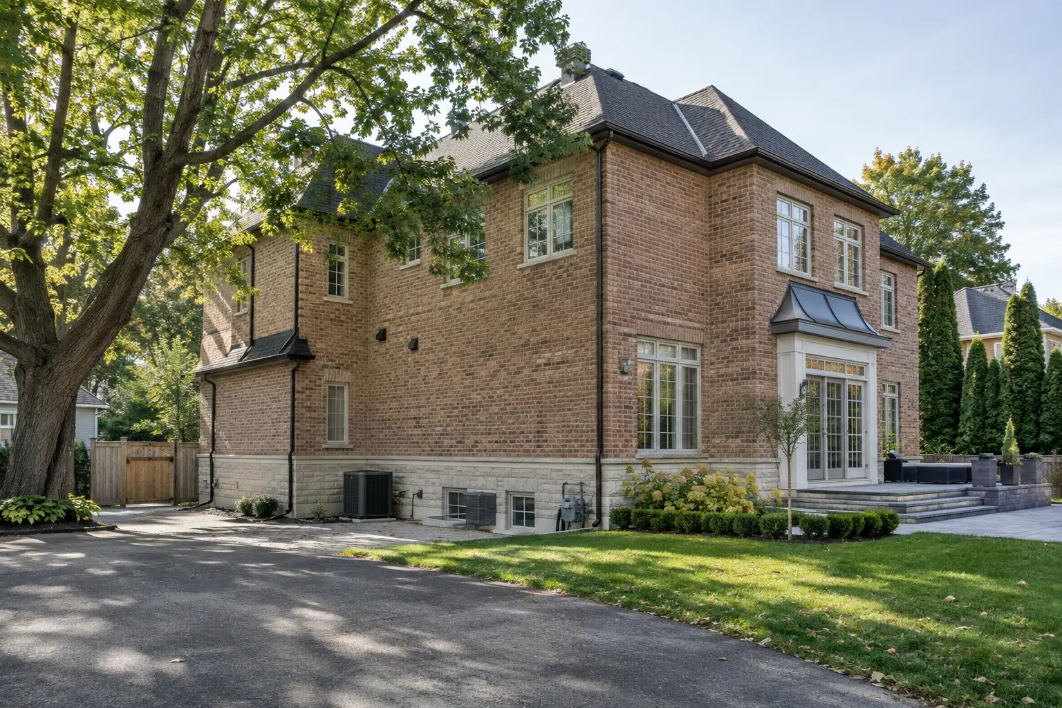 Oakville home exterior with driveway, side setback and mature tree visible.